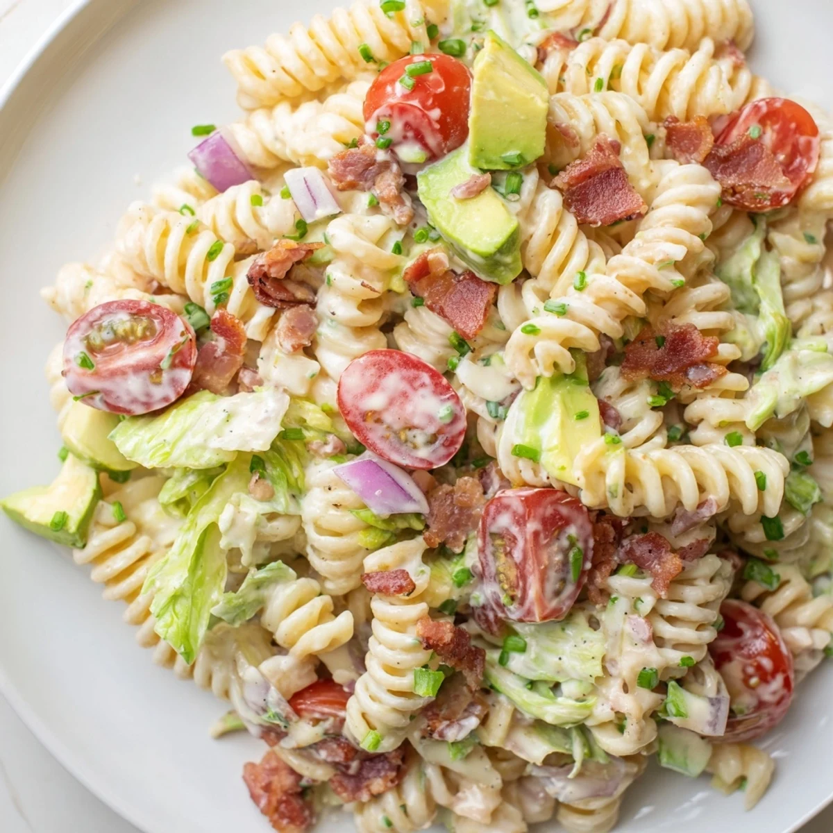 BLT Pasta Salad, a colorful mix of pasta, bacon crumbles, and fresh tomatoes, ready to serve.