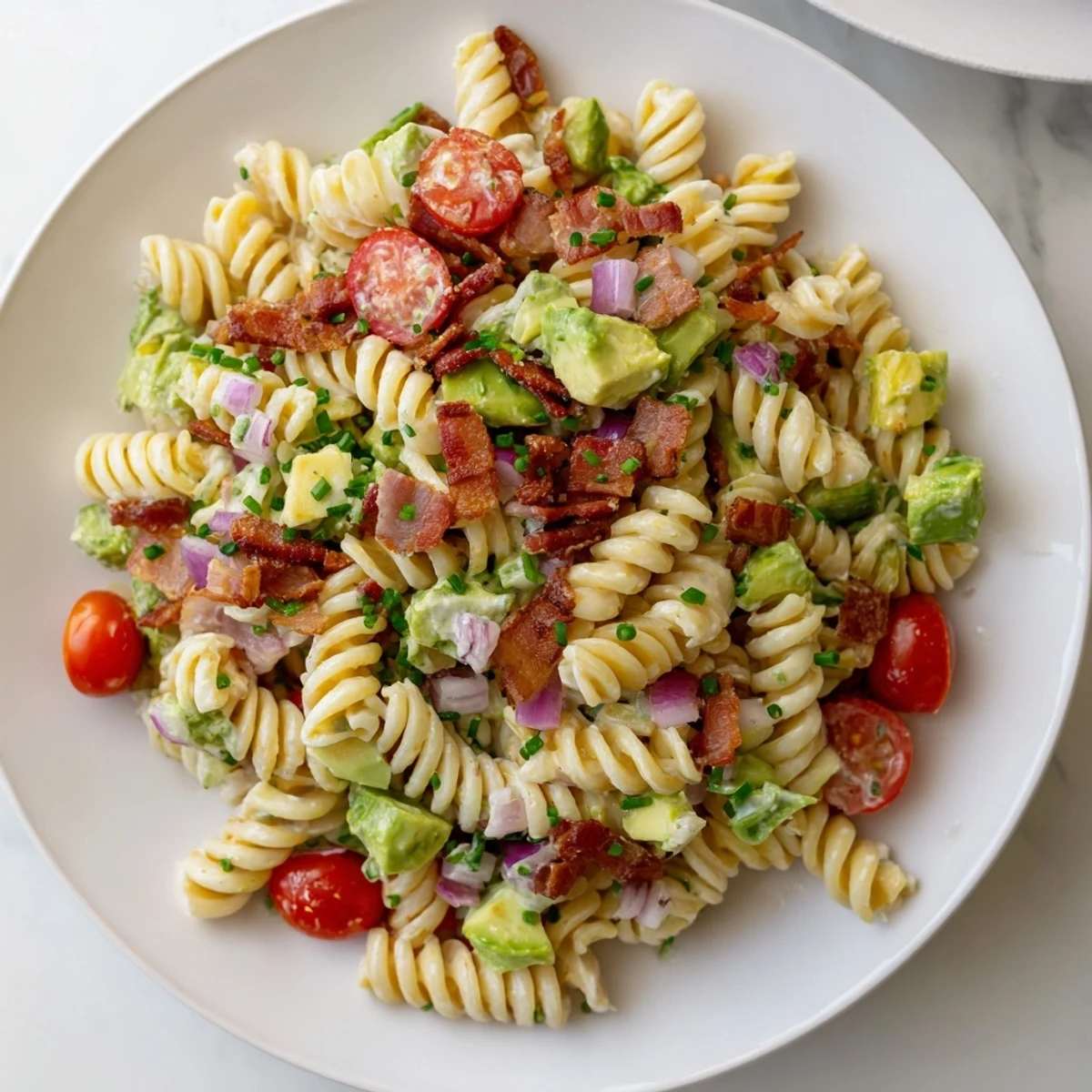 Creamy BLT Pasta Salad overflowing with pasta, bacon, and vibrant vegetables, a summer favorite.