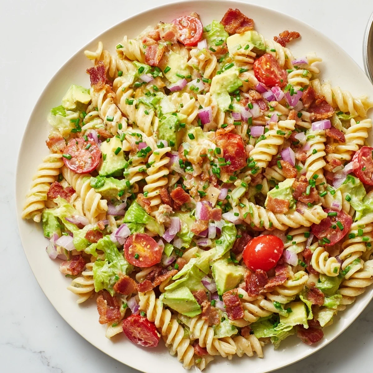 This BLT Pasta Salad showcases crisp lettuce and bacon bits, mixed with perfectly cooked pasta.
