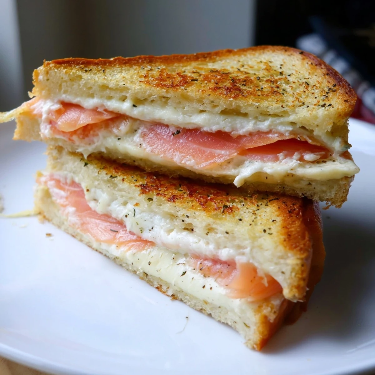 Golden, crispy Smoked Salmon Grilled Cheese sandwich with melted cheese and flaky salmon visible.