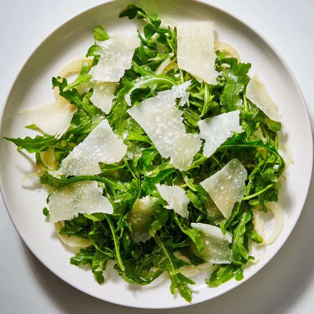 Fresh arugula salad with bright lemon dressing, Parmesan shavings, ready to serve as a starter.