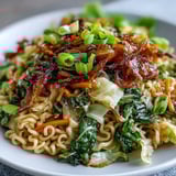 Chopsticks lifting a bite of savory Fried Cabbage Ramen and crunchy vegetables.