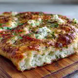 Warm, bubbly Fluffy Cottage Cheese Flatbread stacked on a plate, ready to be served with creamy hummus or dip.