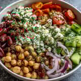 Colorful Greek Bean Salad with lemon-oregano dressing, Kalamata olives, red onion, and fresh herbs served for lunch.