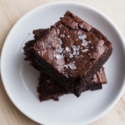 Warm homemade dark chocolate and sea salt brownies, with cracked tops and a sea salt finish.