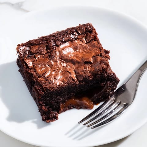 A freshly baked Ina Garten Brownie Pudding, presented with a scoop of vanilla ice cream, ready to enjoy.