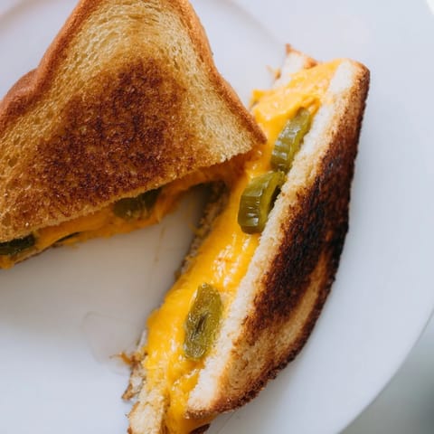 Served warm and cut diagonally, this spicy Cheddar Jalapeño Grilled Cheese is paired perfectly with a bowl of tomato soup.