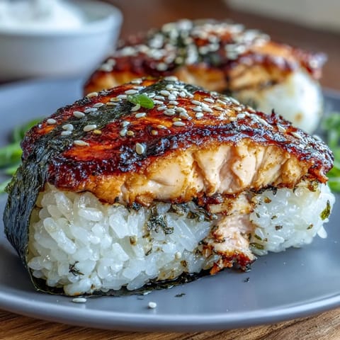Juicy grilled salmon onigiri, triangle-shaped, showing perfectly fused sticky rice.