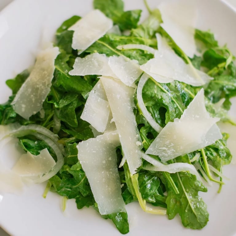 This flavorful arugula salad with lemon dressing features peppery greens and sharp, salty Parmesan cheese.