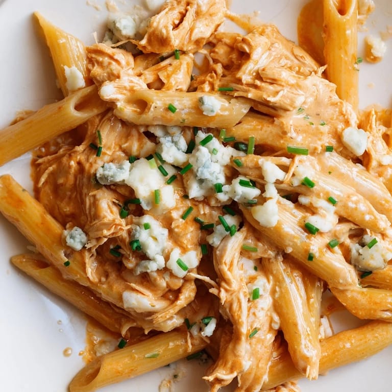 Buffalo Chicken Pasta served in a bowl with a side of celery, highlighting tender pasta coated in a bold, creamy sauce.