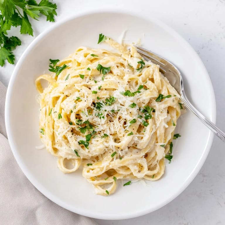 Golden roasted cauliflower florets blend with garlic and Parmesan to create this lighter Alfredo pasta, served steaming and ready to enjoy.