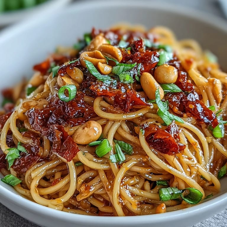 Enjoy spicy Chili Crisp Noodles, featuring chewy noodles coated in flavorful chili oil and garnished.