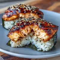 Golden grilled salmon onigiri, seared crisp, ready for dipping in soy sauce.